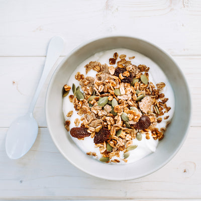 Photographie d'un bol rempli de granola chaï Isabelle Huot et de yogourt. Photograph of a hand holding a bowl full of chaï cereal of Isabelle Huot and yogourt. *conçu pour respecter les besoins des personnes atteintes de diabète, d'hypercholestérolémie ou d'hypertension artérielle
